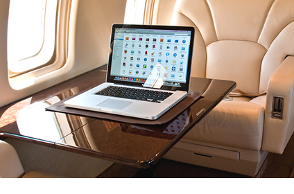 Laptop open on a table inside a private jet